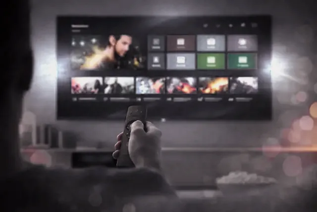 A remote pointed at a television showing a player’s channel menu