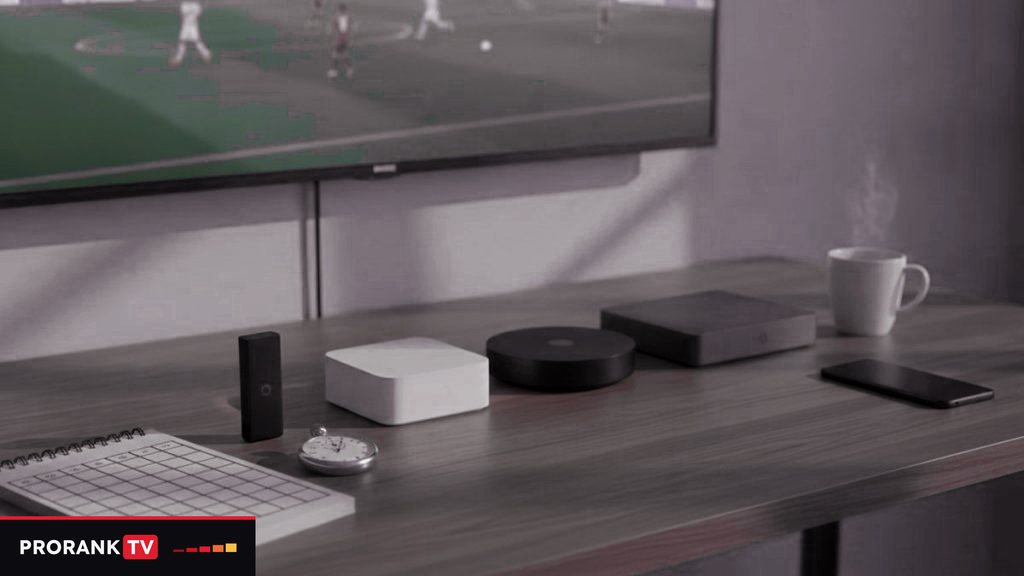 Cover for “Choosing the best IPTV service for your household and your languages”: streaming devices, a notebook and a coffee mug on a TV console while a football match plays on screen