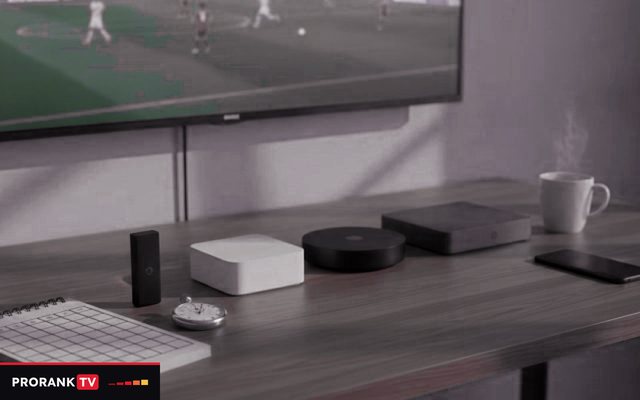 Cover for “Choosing the best IPTV service for your household and your languages”: streaming devices, a notebook and a coffee mug on a TV console while a football match plays on screen