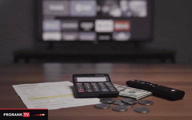 Cover for “How much does IPTV cost? Prices by term, screen count and goal”: a calculator with a blank display, banknotes, coins and a remote on a table in front of a television